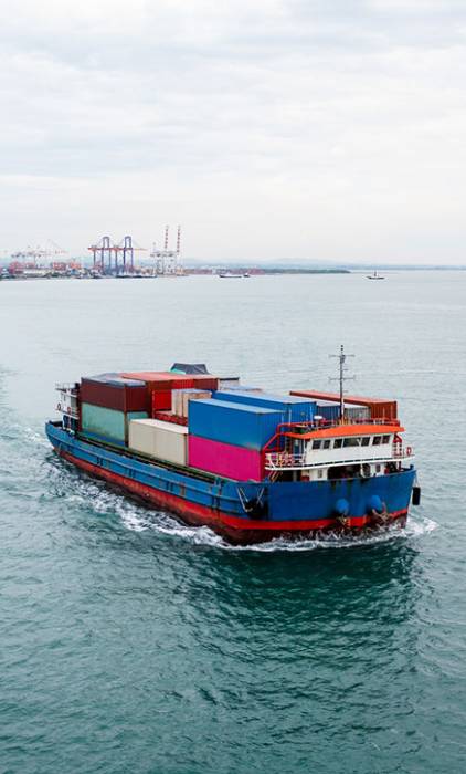 small container ship sailing in sea and shipping port background photograph aerial view from drone
